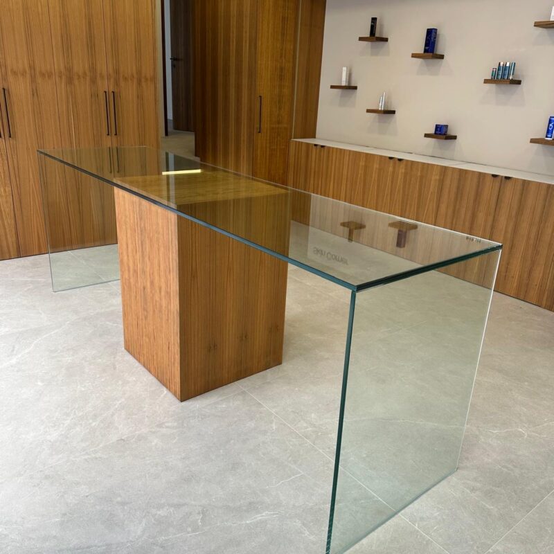Mesa de cristal transparente con pie de madera